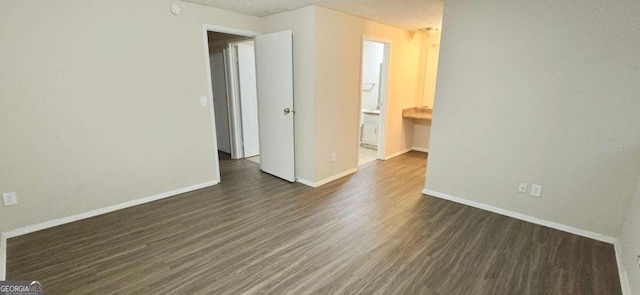 empty room featuring a textured ceiling and dark hardwood / wood-style floors