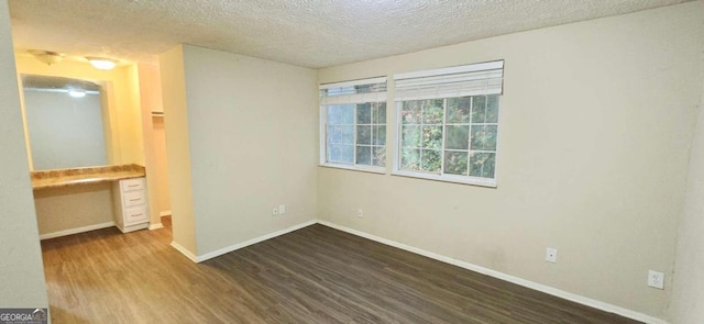 unfurnished bedroom featuring hardwood / wood-style floors, built in desk, and a textured ceiling