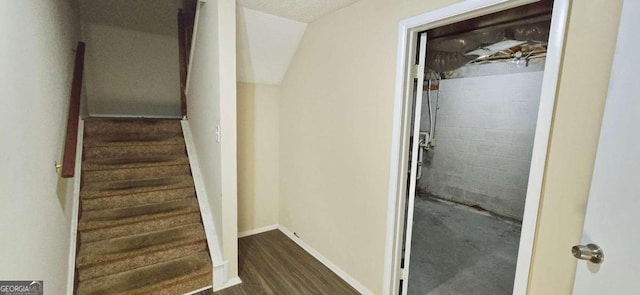 staircase featuring a textured ceiling and hardwood / wood-style flooring