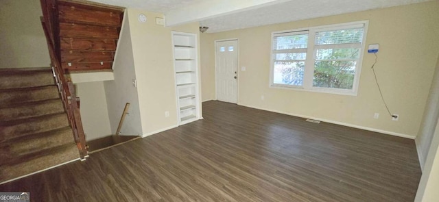 interior space featuring a textured ceiling and dark hardwood / wood-style flooring