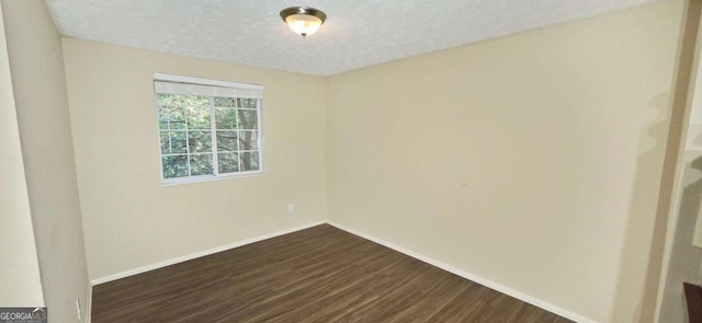 empty room featuring a textured ceiling and dark wood-type flooring