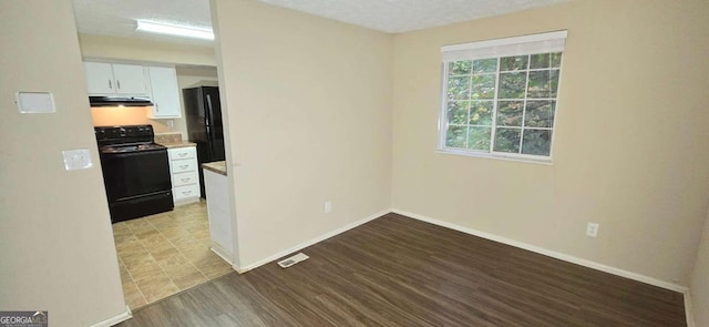 unfurnished room featuring light hardwood / wood-style floors and a textured ceiling