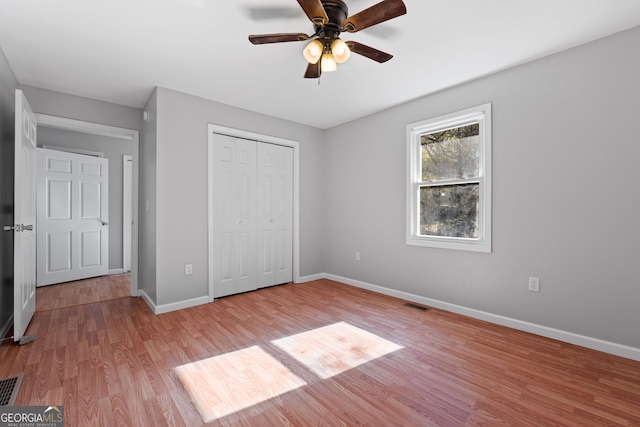 unfurnished bedroom featuring ceiling fan, light hardwood / wood-style flooring, and a closet