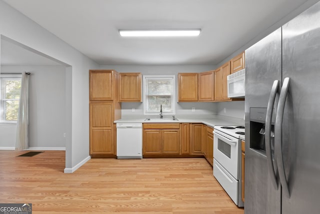 kitchen with light hardwood / wood-style floors, white appliances, and sink