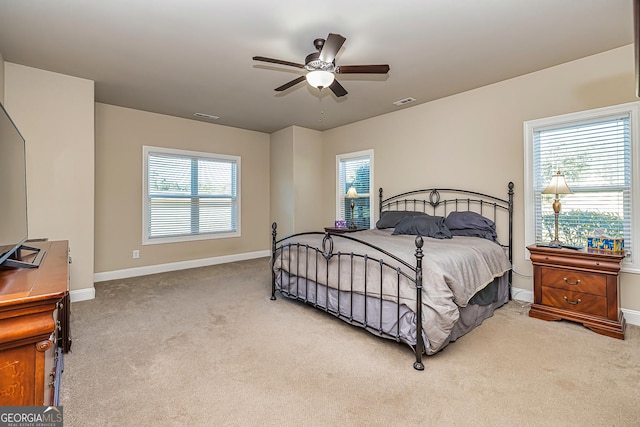 bedroom featuring ceiling fan, carpet floors, and multiple windows