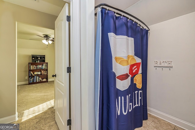 interior space with a shower with shower curtain and ceiling fan