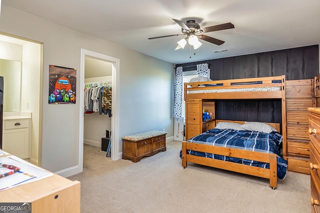 carpeted bedroom with a walk in closet, a closet, and ceiling fan