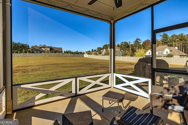 unfurnished sunroom with ceiling fan