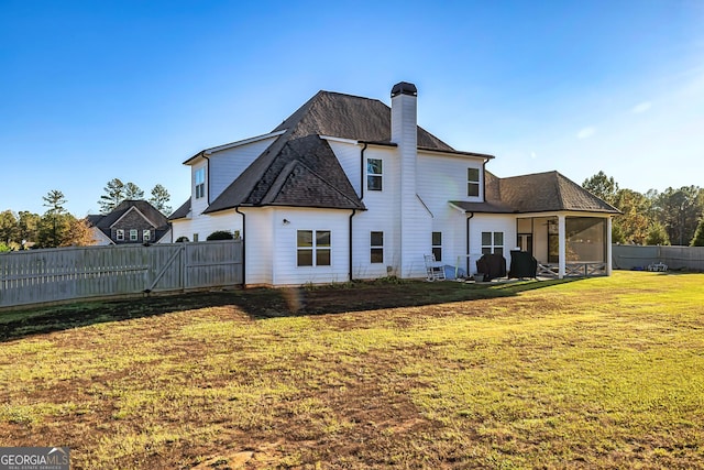 back of house featuring a sunroom and a yard