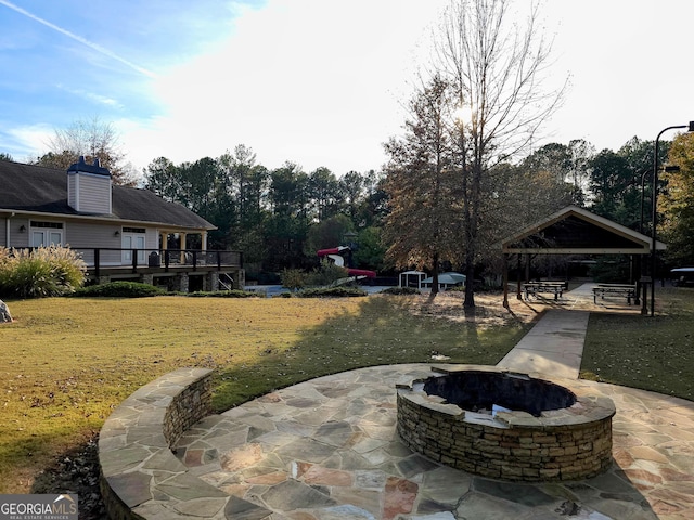 view of patio with a gazebo, a wooden deck, and a fire pit