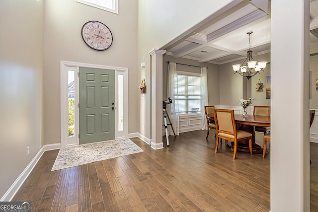 foyer entrance with coffered ceiling, hardwood / wood-style flooring, ornamental molding, a notable chandelier, and beam ceiling