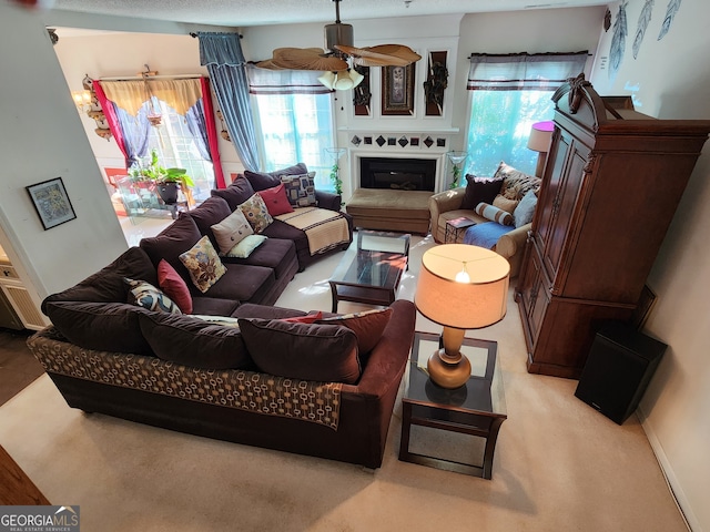 living room featuring ceiling fan and a textured ceiling