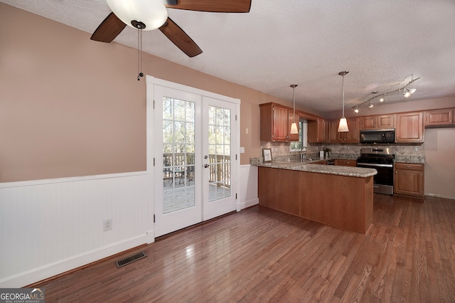 kitchen with stainless steel range, dark hardwood / wood-style flooring, kitchen peninsula, pendant lighting, and a textured ceiling