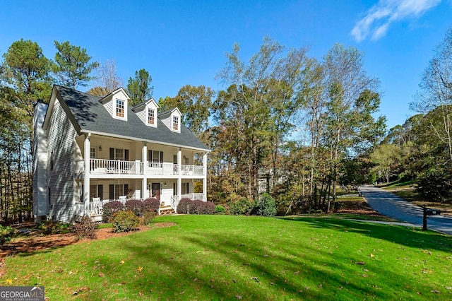 new england style home featuring a porch and a front lawn