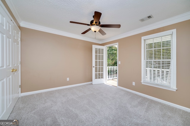 spare room with light carpet, crown molding, and a textured ceiling