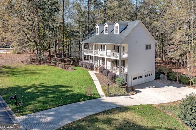 view of front facade featuring a front yard, a balcony, and a garage