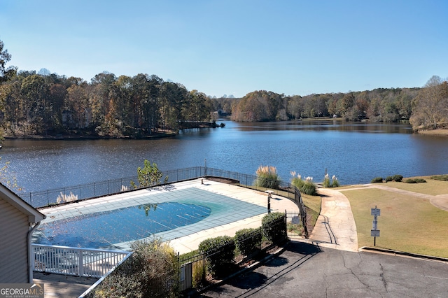 view of swimming pool with a patio area and a water view