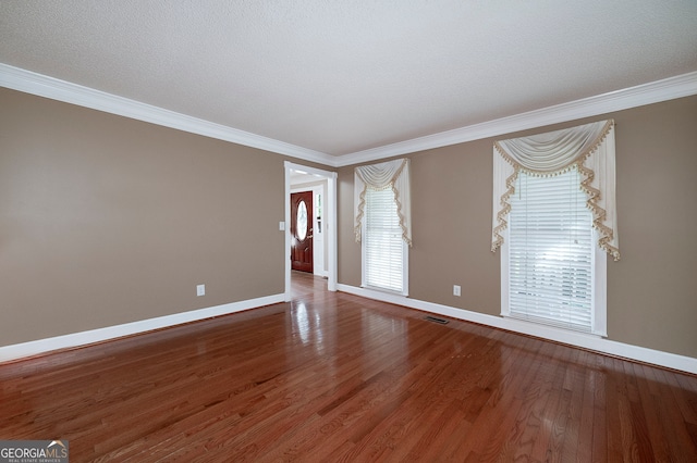 unfurnished room with wood-type flooring, a textured ceiling, and ornamental molding