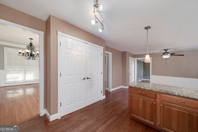 kitchen with dark hardwood / wood-style flooring, light stone countertops, and a textured ceiling