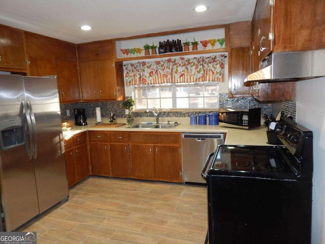 kitchen featuring backsplash, light hardwood / wood-style floors, sink, and stainless steel appliances