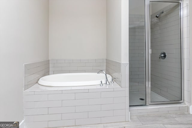 bathroom featuring separate shower and tub