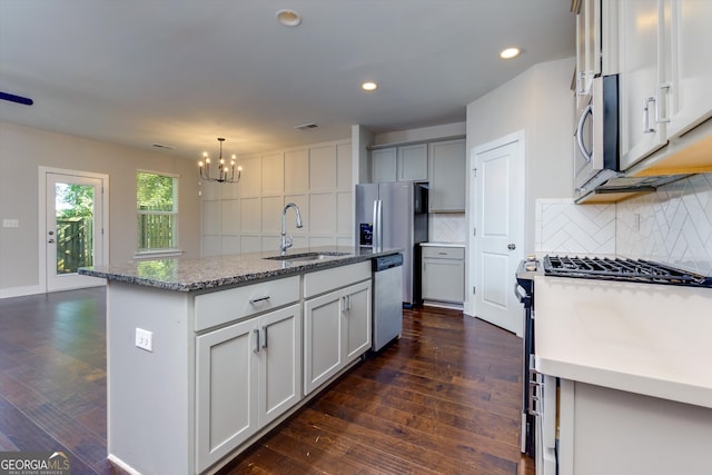 kitchen with a center island with sink, dark hardwood / wood-style flooring, sink, and appliances with stainless steel finishes