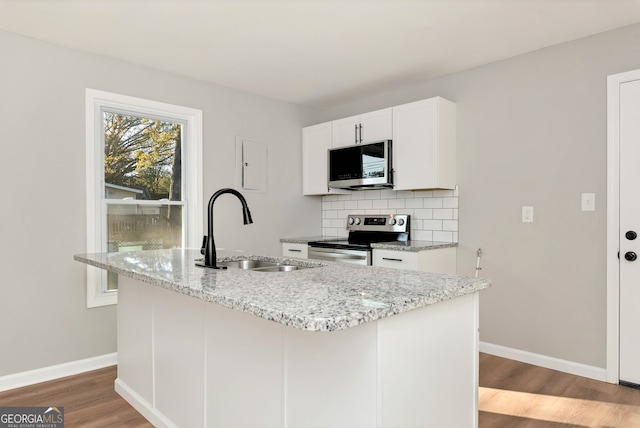 kitchen with white cabinetry, sink, stainless steel appliances, light hardwood / wood-style flooring, and an island with sink