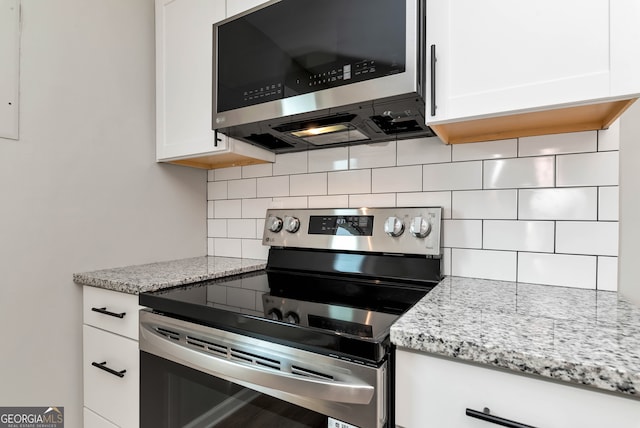 kitchen with backsplash, light stone countertops, white cabinetry, and stainless steel appliances