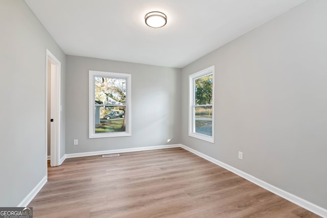 spare room with light hardwood / wood-style floors and a healthy amount of sunlight