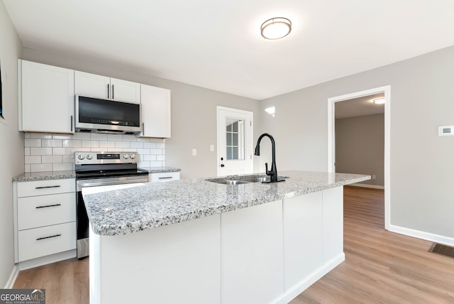 kitchen with white cabinets, a center island with sink, sink, and appliances with stainless steel finishes