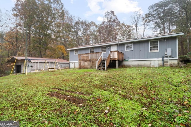 back of property featuring a lawn and a wooden deck