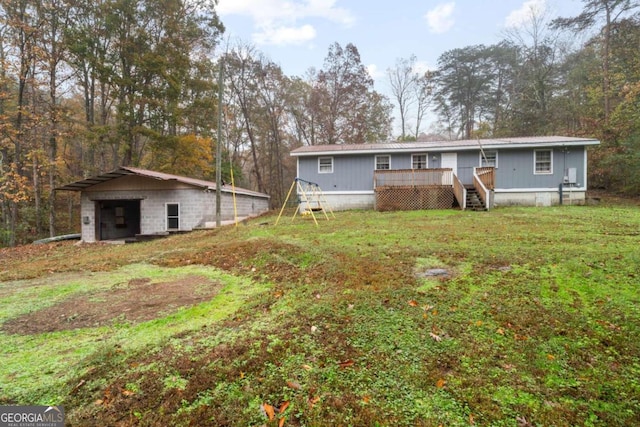 rear view of property featuring an outbuilding and a wooden deck