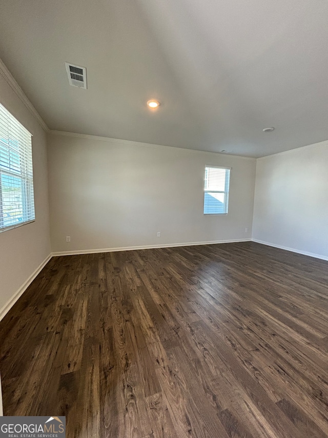 spare room featuring dark hardwood / wood-style flooring and ornamental molding