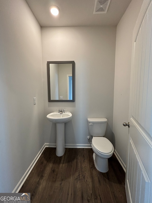 bathroom with hardwood / wood-style flooring, toilet, and sink