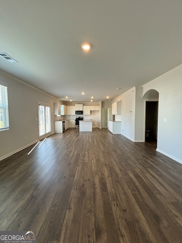 unfurnished living room featuring dark hardwood / wood-style floors and crown molding