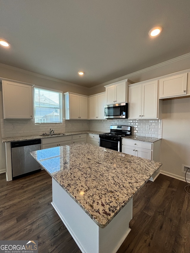 kitchen featuring white cabinets, dark hardwood / wood-style floors, a center island, and stainless steel appliances