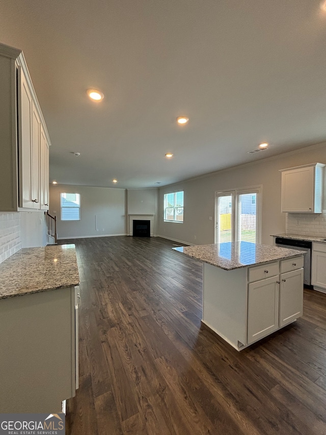 kitchen with a center island, white cabinets, dark wood-type flooring, and stainless steel dishwasher