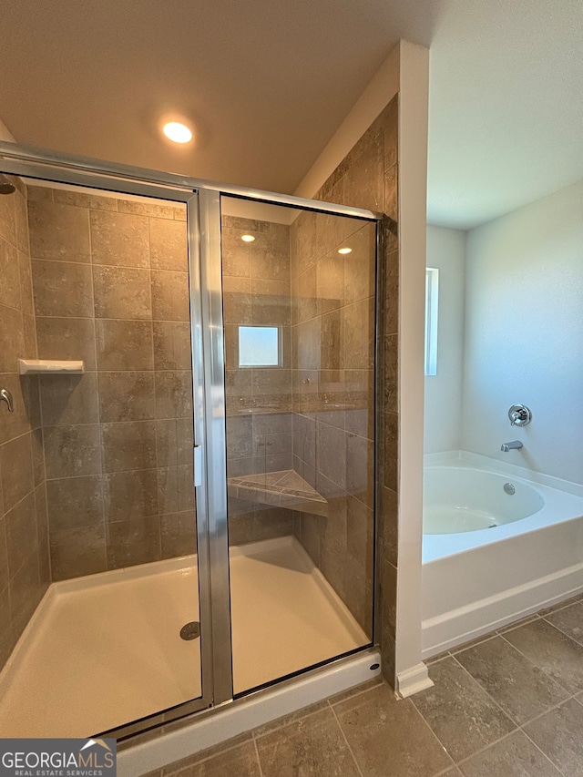 bathroom with tile patterned flooring and separate shower and tub