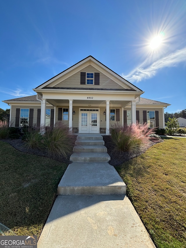 view of front of house with a front yard and french doors