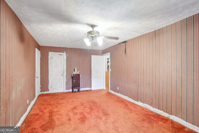 empty room with a textured ceiling, carpet floors, and ceiling fan