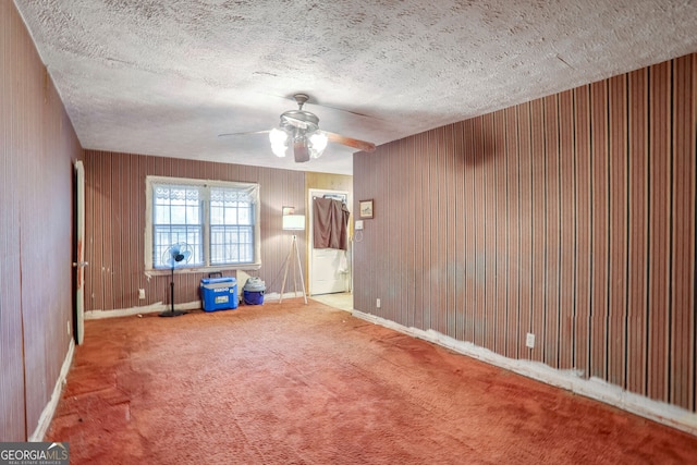 unfurnished room featuring a textured ceiling, carpet floors, and ceiling fan