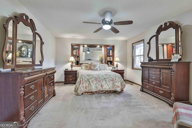 carpeted bedroom with ceiling fan and a textured ceiling