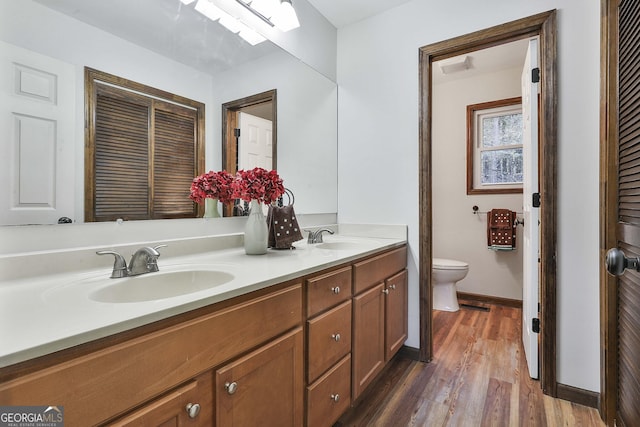 bathroom featuring wood-type flooring, vanity, and toilet