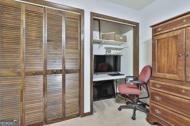 carpeted home office with a textured ceiling