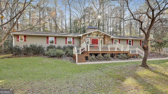 ranch-style home with a front lawn and a deck