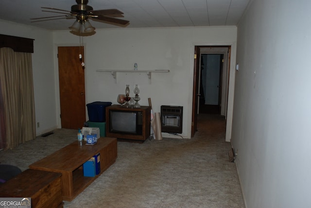 carpeted living room with ceiling fan and heating unit