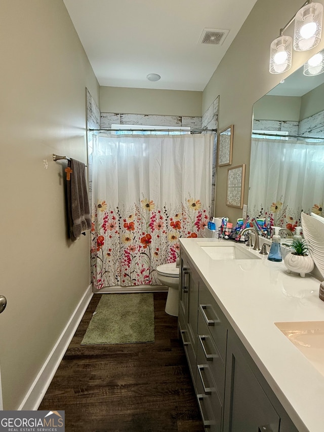 bathroom with toilet, vanity, and hardwood / wood-style flooring