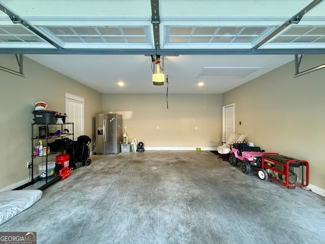 garage featuring stainless steel fridge and a garage door opener