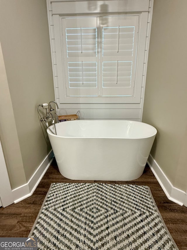 bathroom with hardwood / wood-style floors and a tub