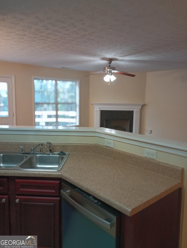 kitchen featuring ceiling fan, dishwasher, sink, and a textured ceiling